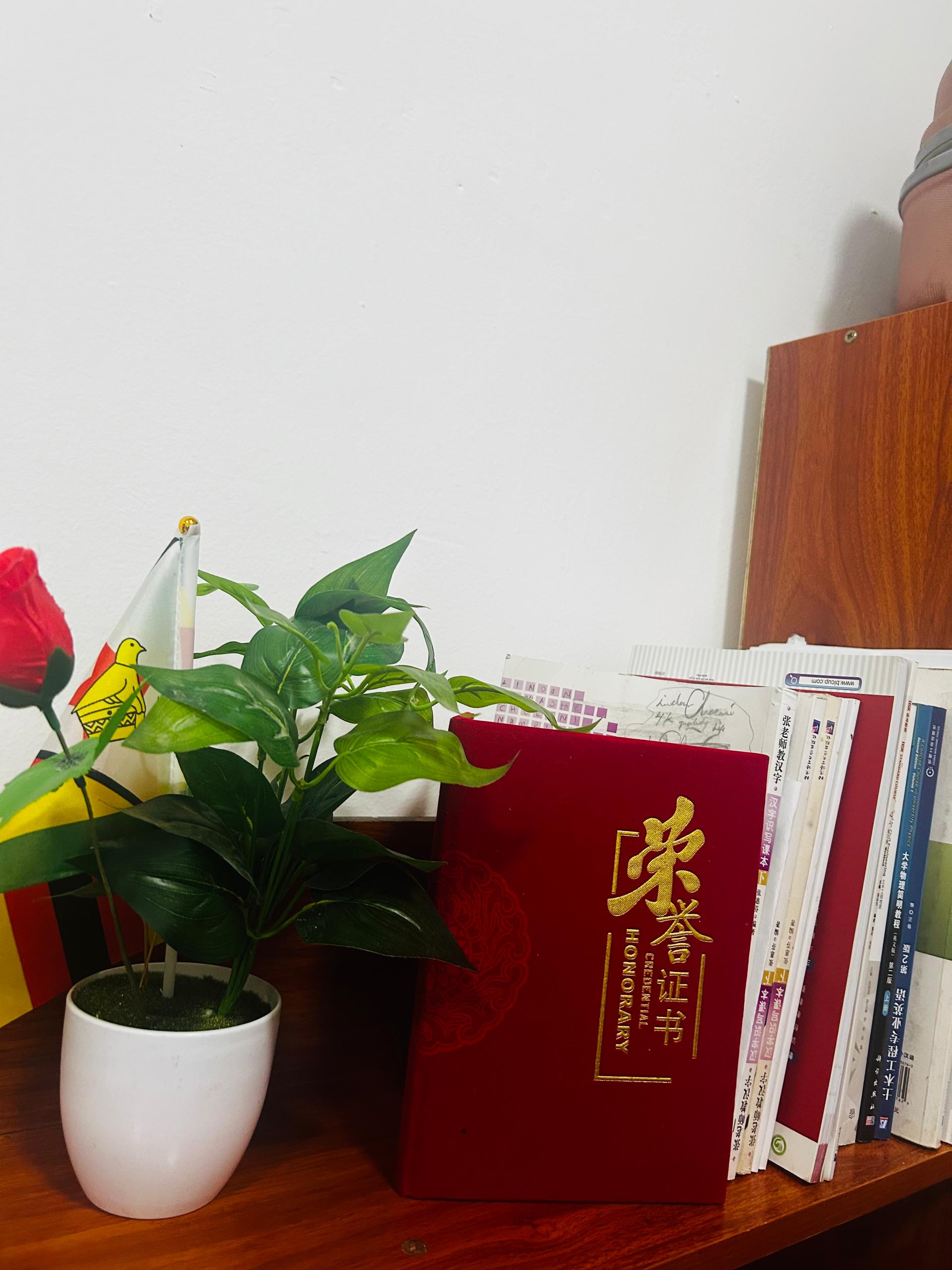 Study desk with honour certificate, books and flags symbolising academic achievement