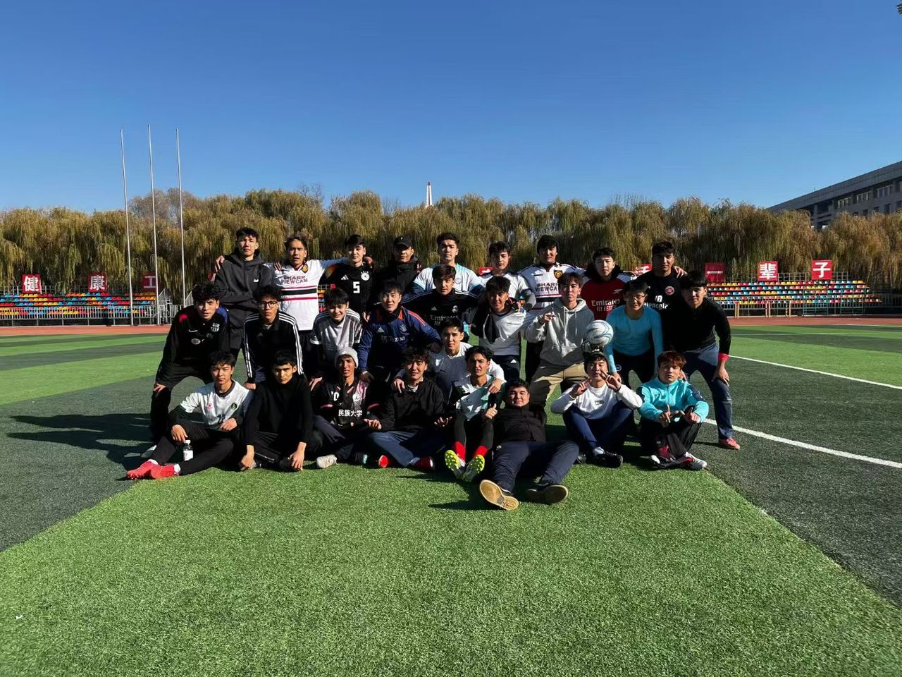 Students celebrating together on a football pitch during the day