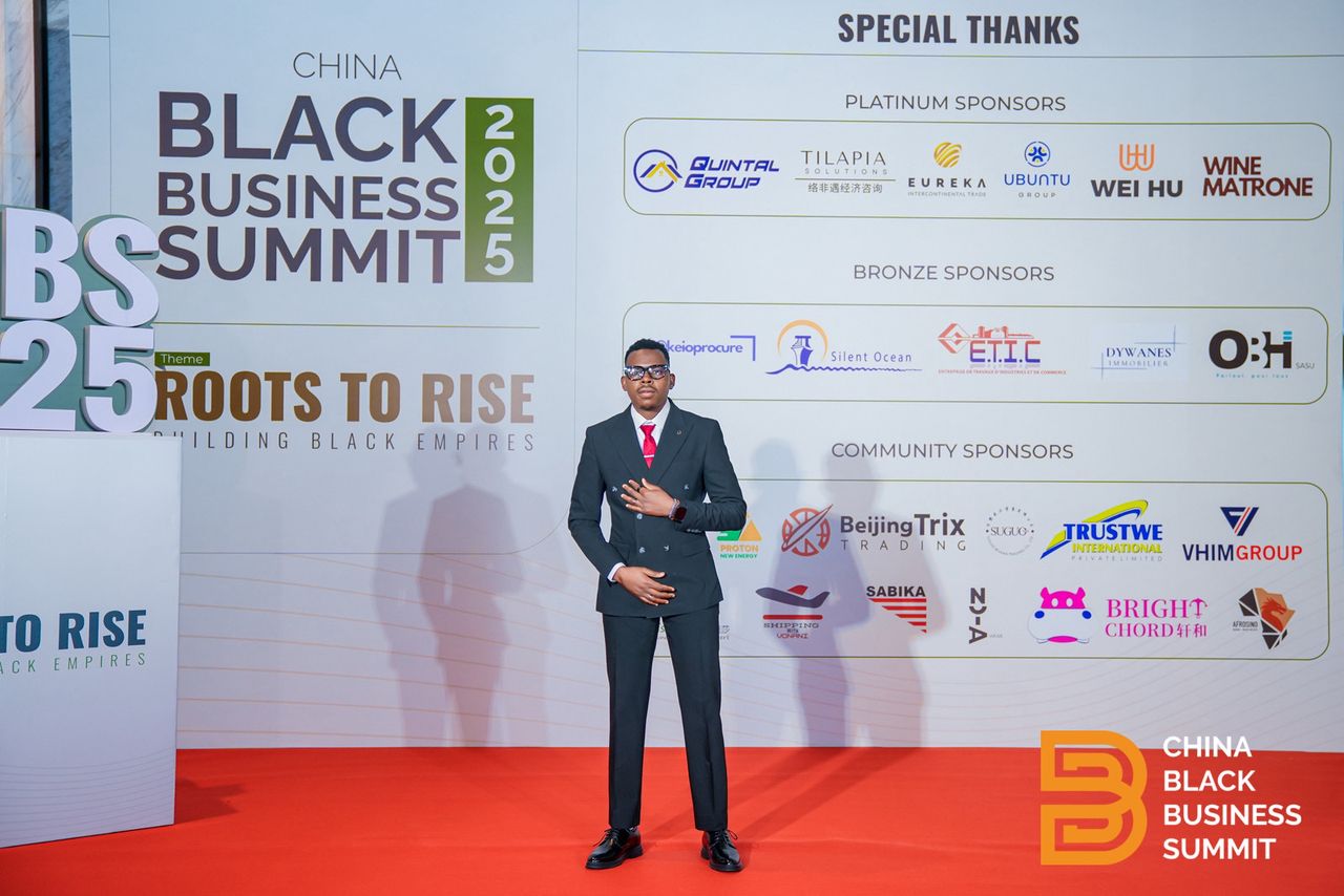 Speaker standing in front of sponsor wall at the summit